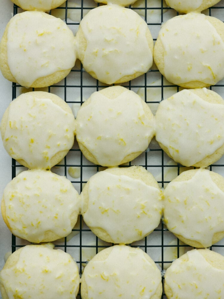 The top view of glazed lemon ricotta cookies on a wire baking rack. 