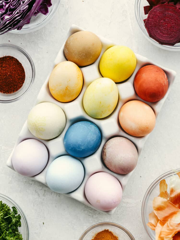 Top-down view of 12 dyed Easter eggs in a carton.