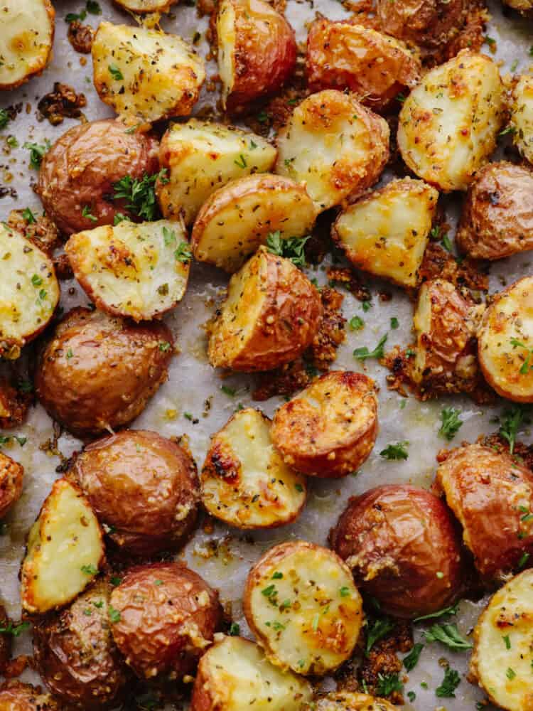 Closeup of potatoes, covered with parmesan and herbs.