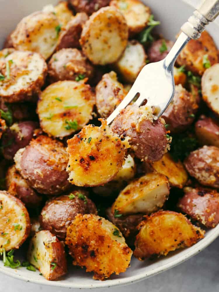 Closeup of skewering two potatoes with a fork.