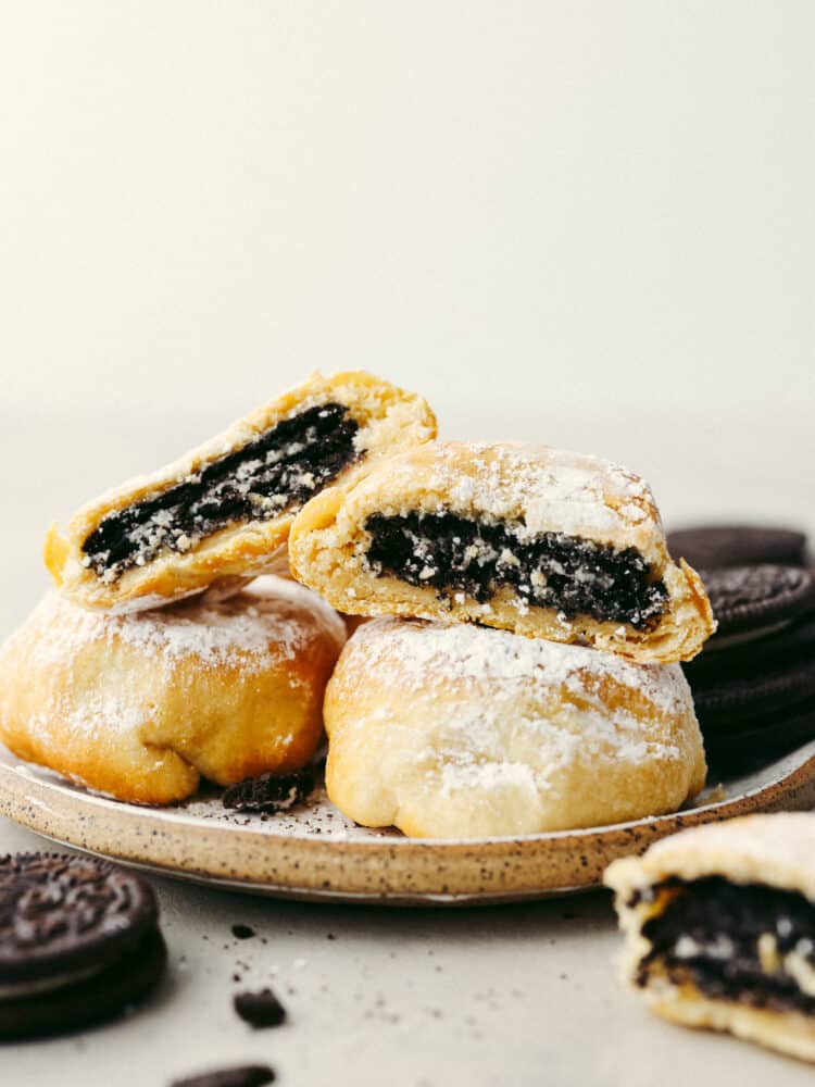 A stack of 4 fried Oreos, 2 of which are split in half so the Oreo filling can be seen.