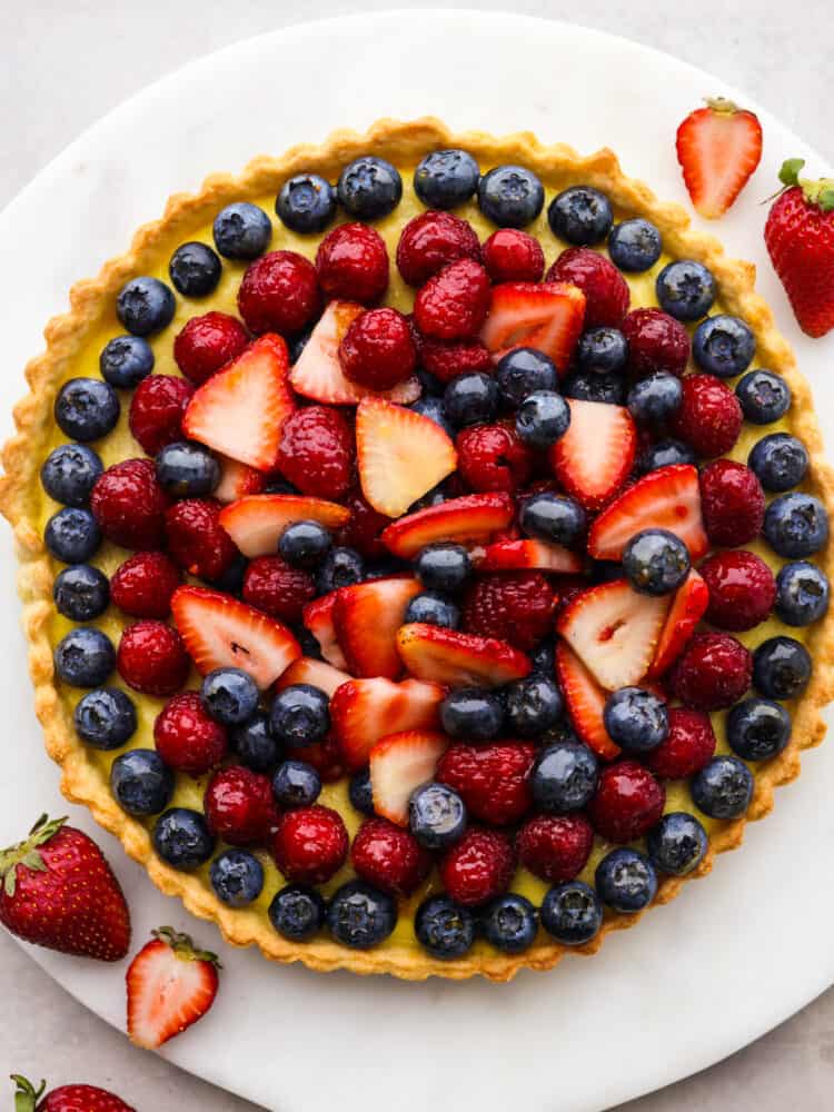 Top-down view of a whole tart on a white plate.