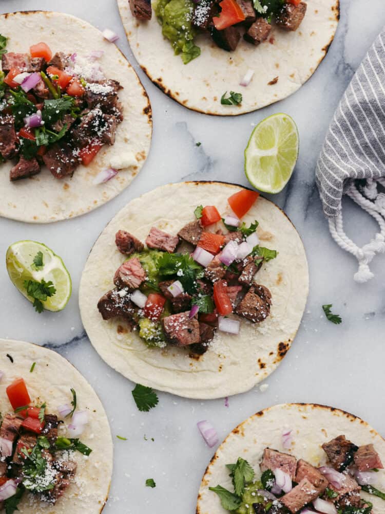 Tortillas laying flat that have toppings on them. 