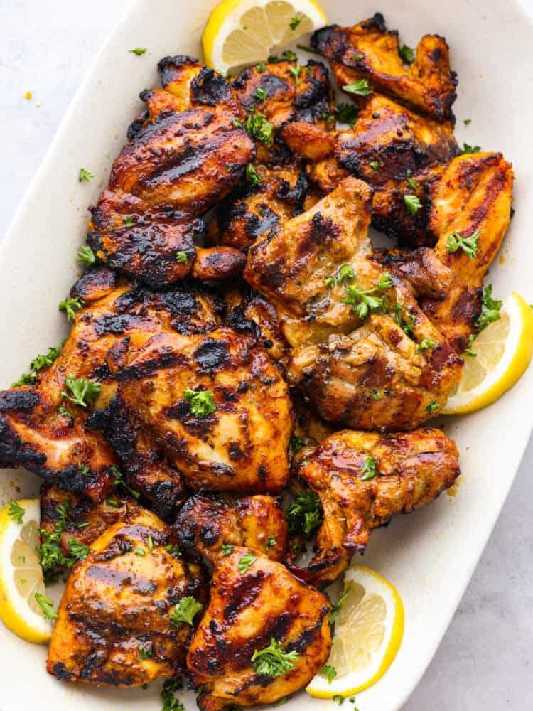 Some grilled chicken on a platter that has been seasoned with shawarma seasoning. 