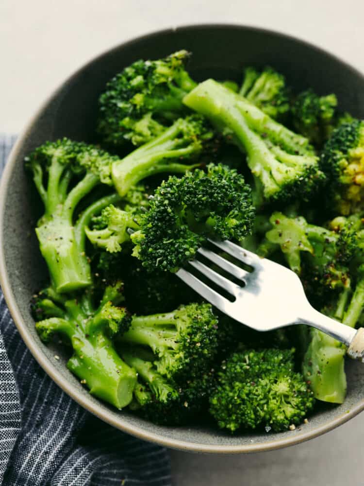Brokoli dalam mangkuk dengan garpu perak, siap untuk dimakan. 