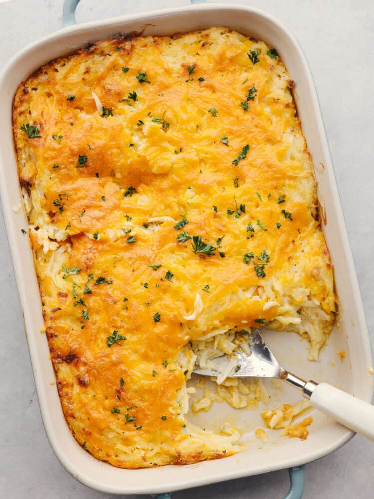 Top-down photo of hashbrown casserole in a white serving dish.
