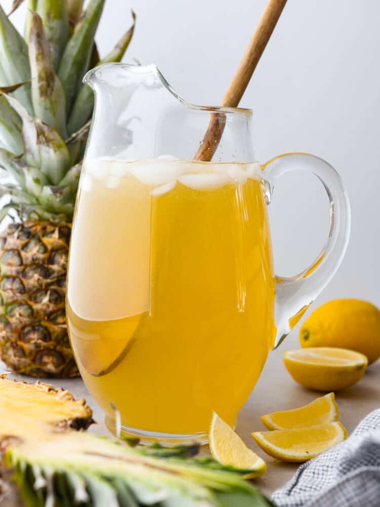 A glass pitcher filled with pineapple lemonade.
