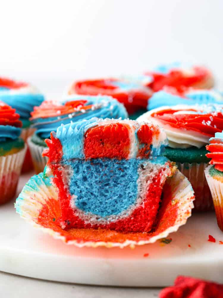 The side view of a red, white and blue cupcake cut open so that you can swee the swirled colors inside. 