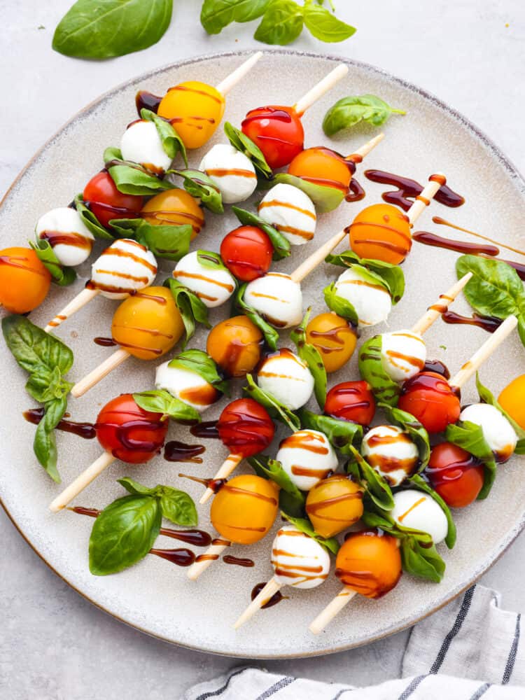 Top-down view of Caprese skewers on a gray plate.