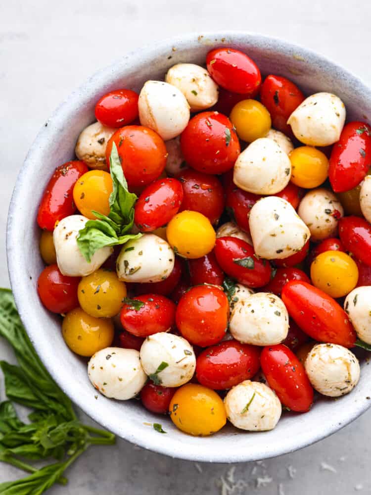 The top view of a bowl of cherry tomato salad. 