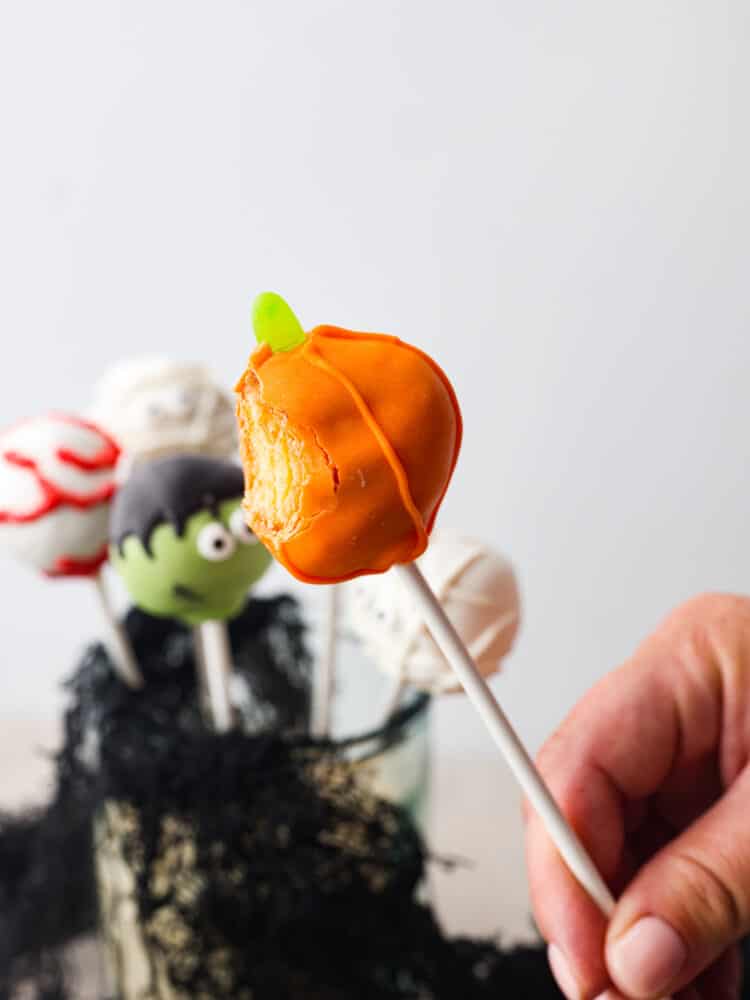 A pumpkin shaped donut hole pop with a bite taken out of it TeamJiX