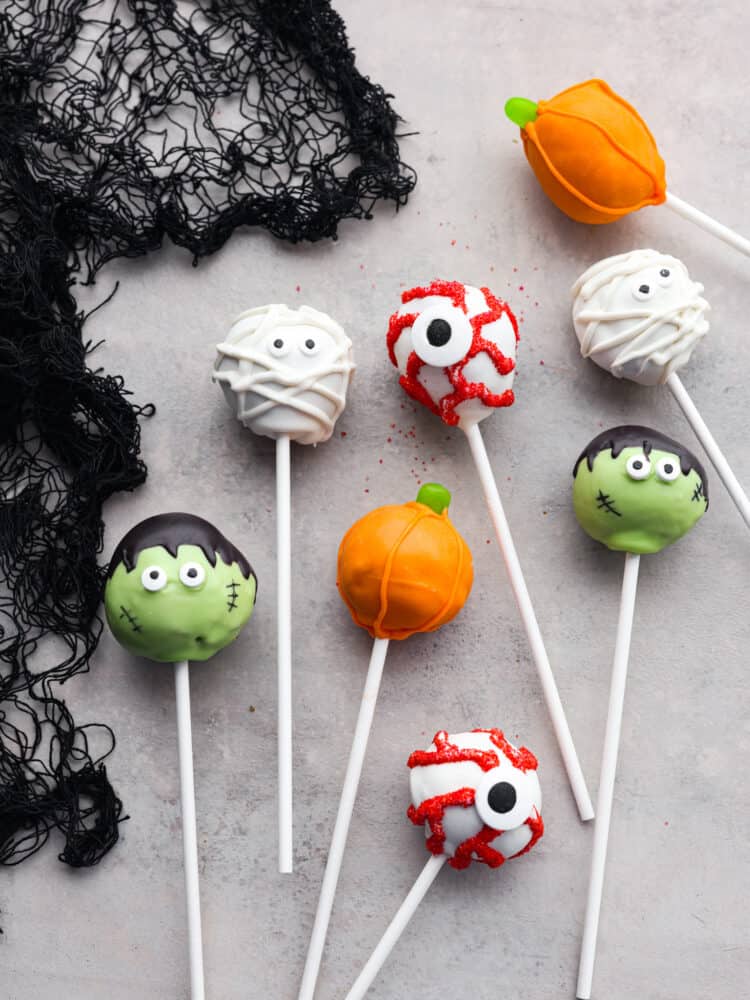 Top-down view of donut hole pops decorated like various Halloween characters.