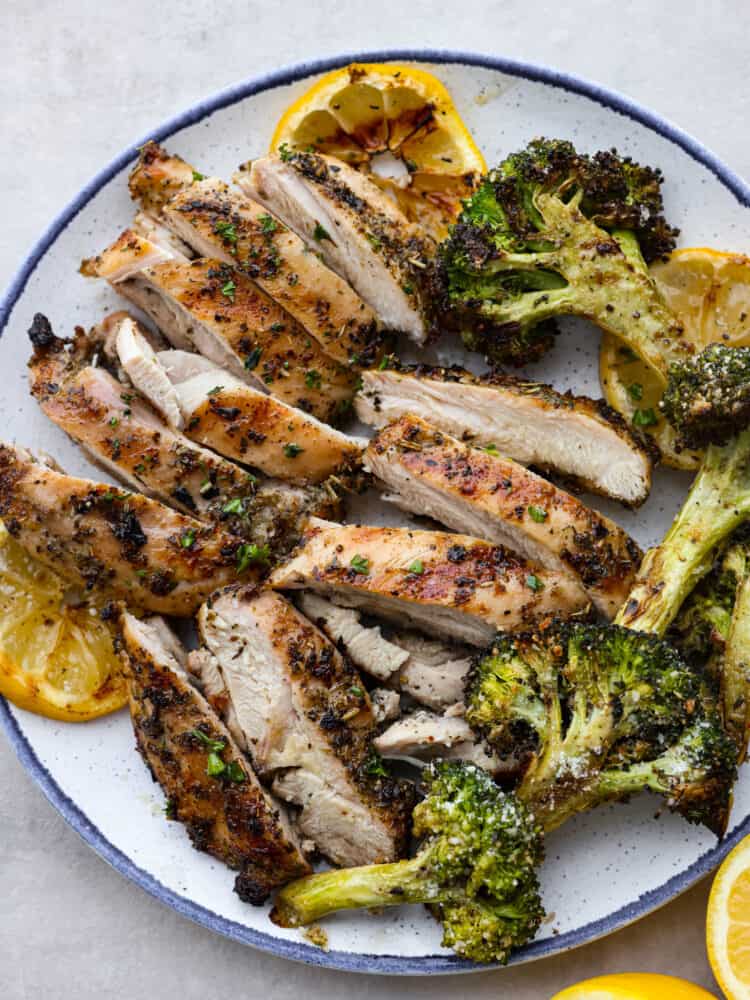 A plate with sliced chicken and grilled broccoli. 