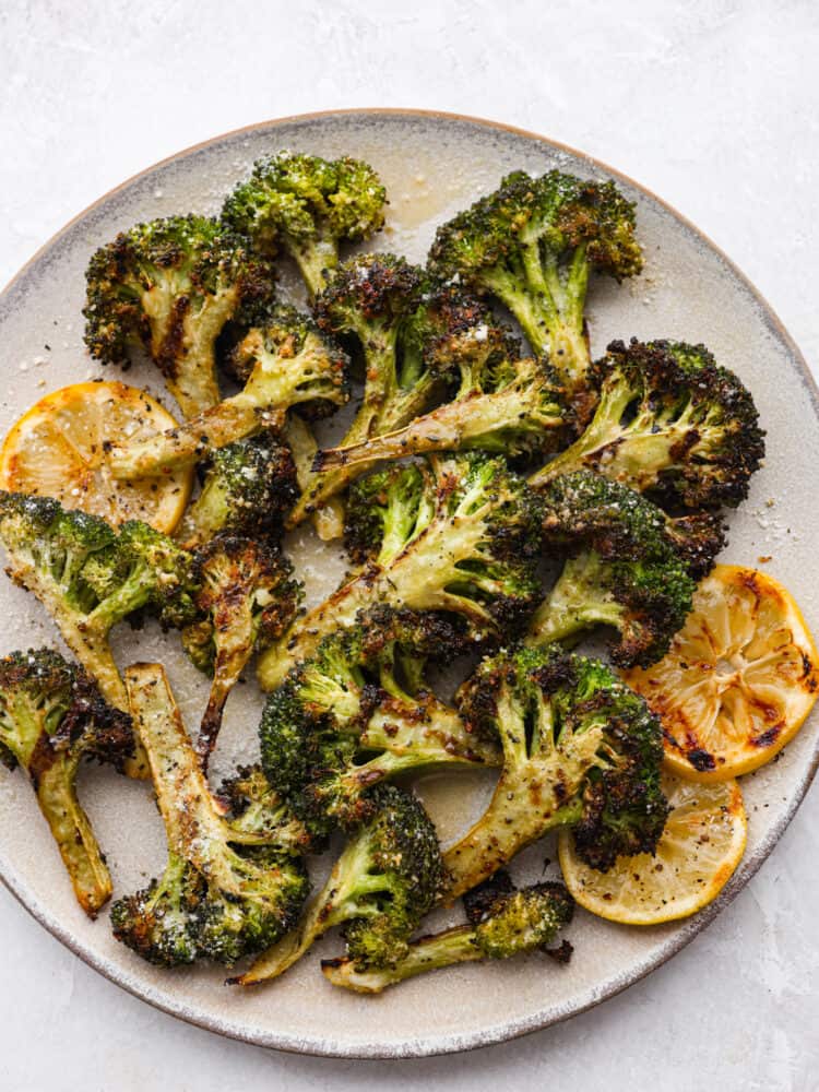 Top-down view of grilled broccoli on a stoneware plate.