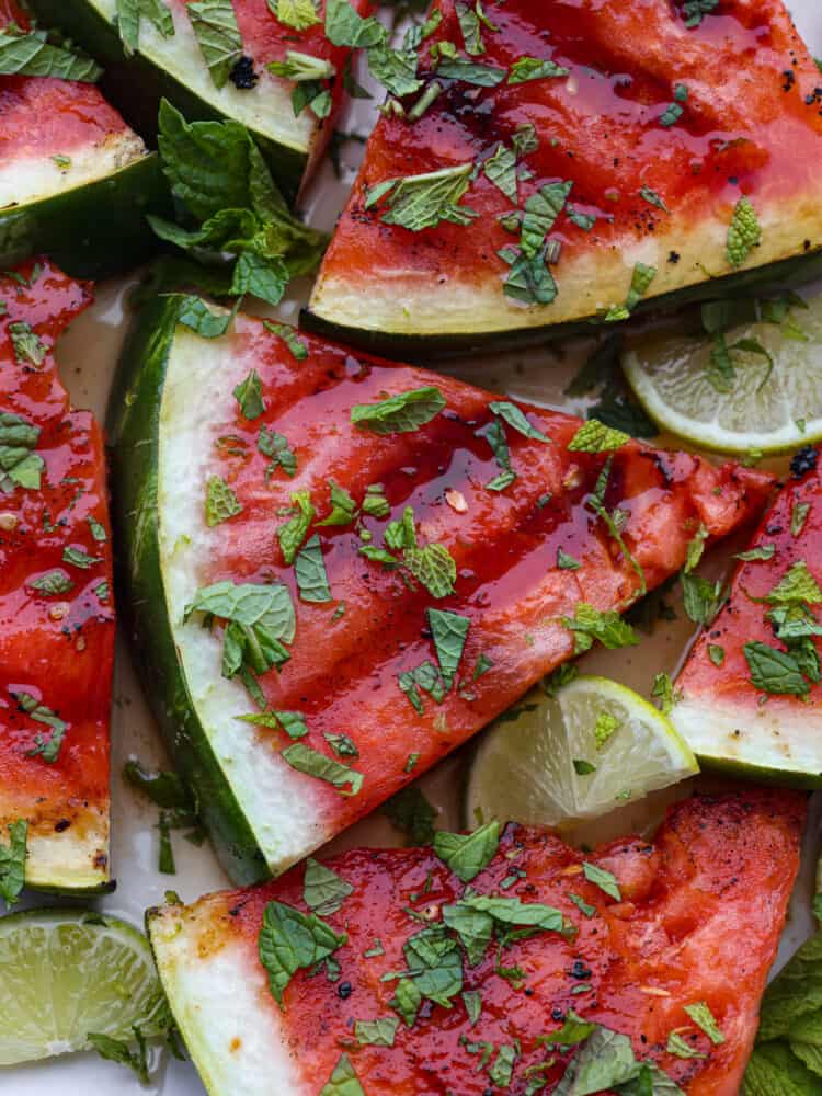 Closeup of grilled watermelon, topped with freshly chopped mint.