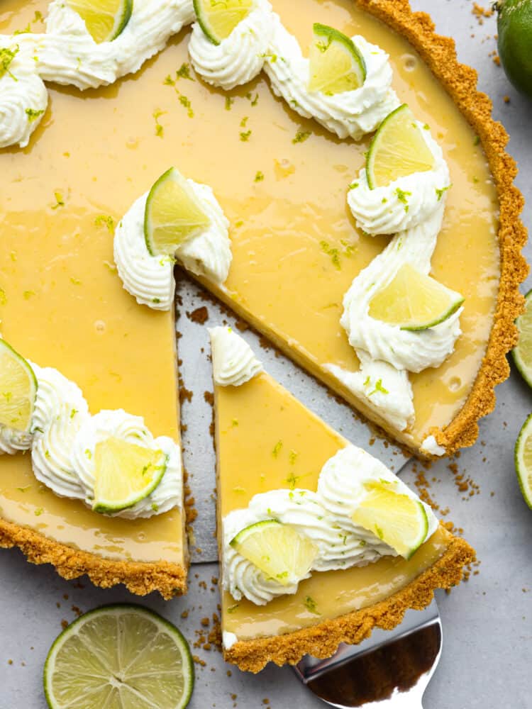 Top-down view of a slice of key lime tart being picked up with a pie server.