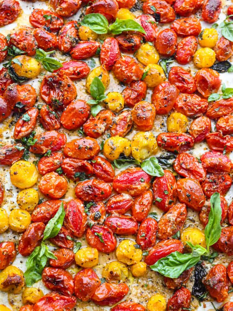 The top view of roasted cherry tomatoes on a baking sheet. 