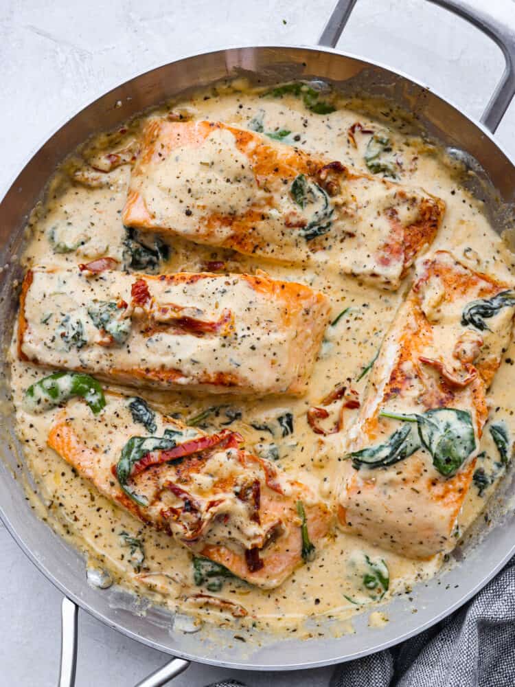 A pan with creamy tuscan garlic salmon all cooked. 
