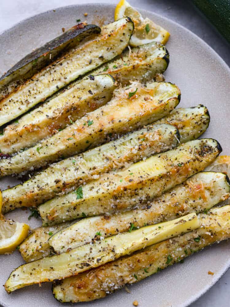 Top-down view of zucchini spears on a gray plate.