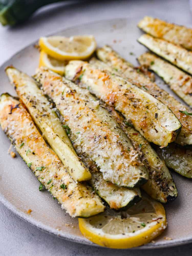 Roasted parmesan garlic zucchini spears on a gray stoneware plate.