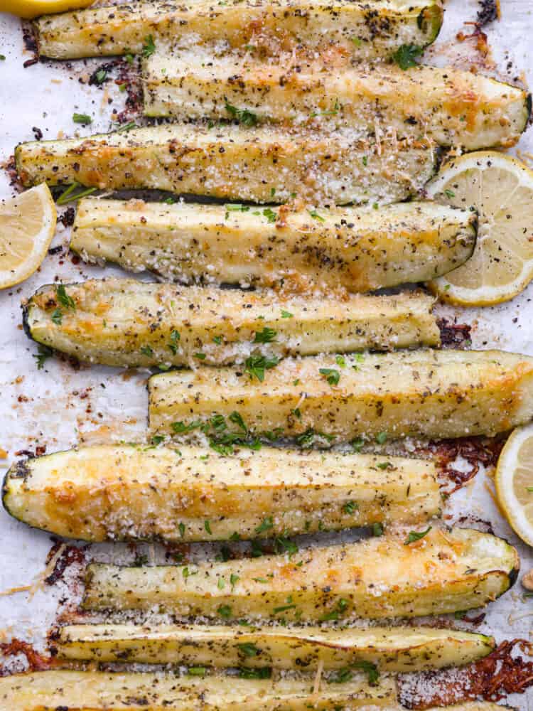 Closeup of roasted zucchini spears seasoned with garlic and parmesan.