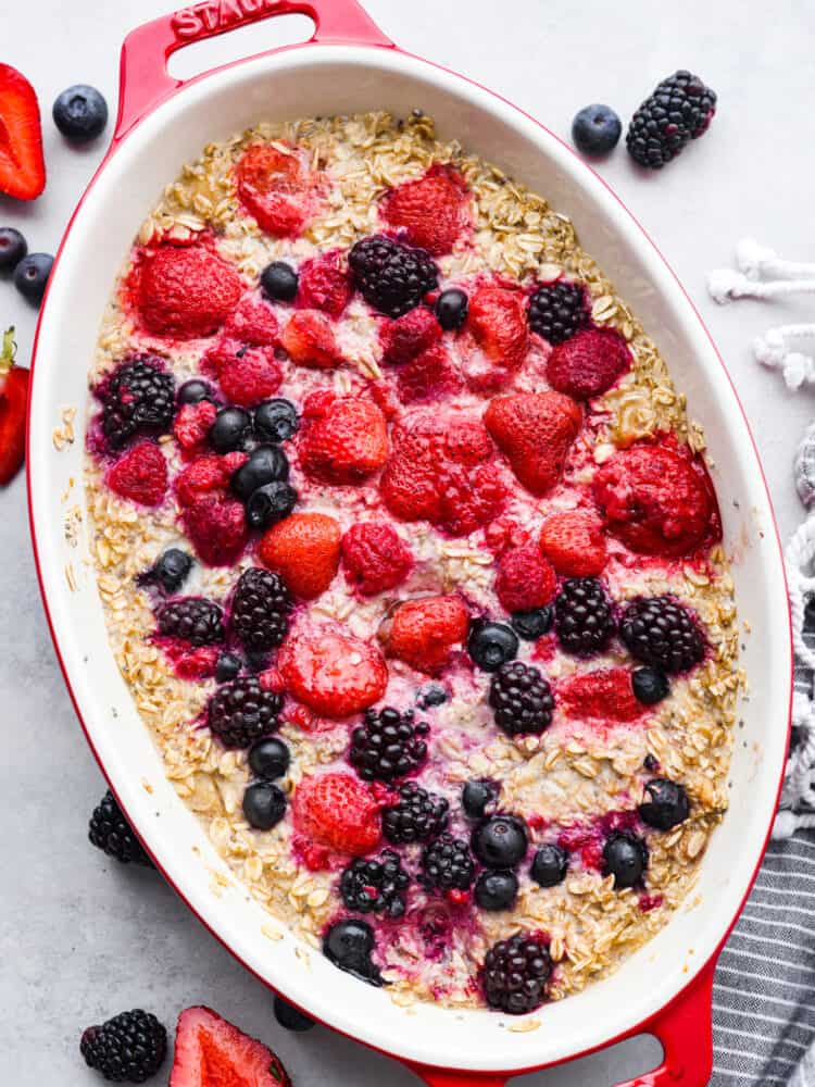 Top-down view of oatmeal in a baking dish, garnished with fresh berries.