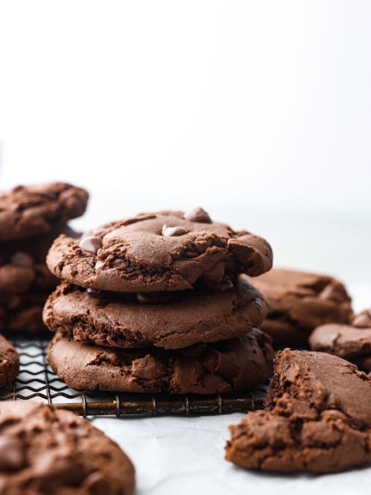 A stack of chocolate cake mix cookies on a cooling rack. 