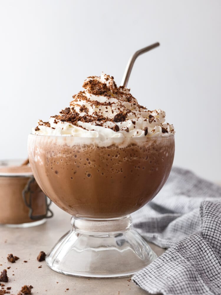 Bevroren warme chocolademelk in een glazen beker, bestrooid met cacao.