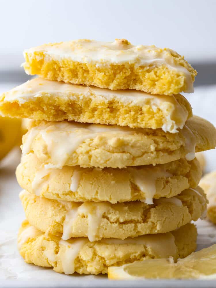 A stack of lemon cake mix cookies. The top one is broken in half and stacked. 