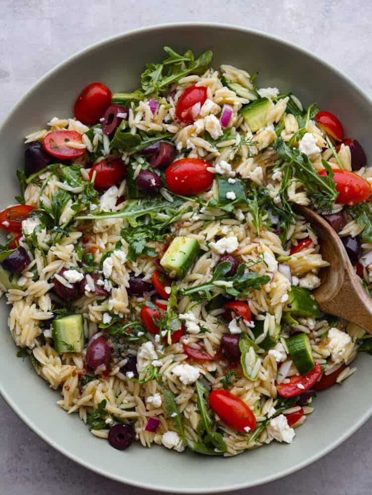 The top view of a bowl of Greek orzo salad. 