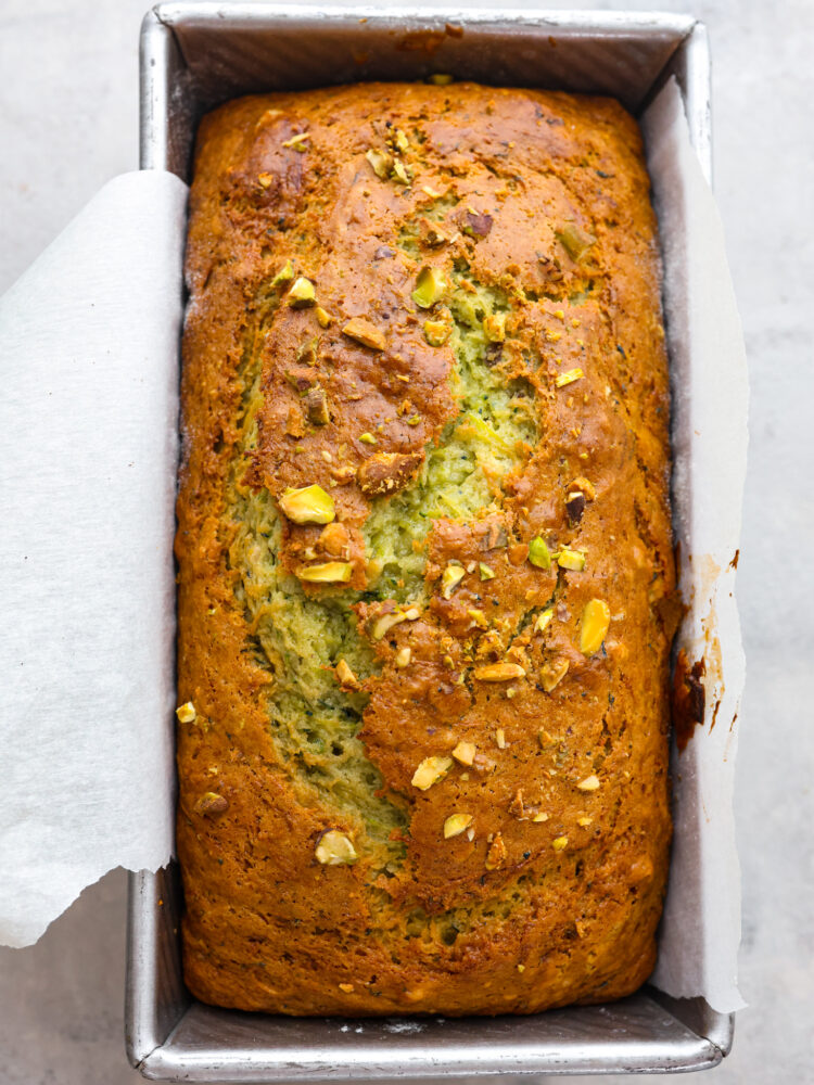 The top view of pistachio zucchini bread in a loaf pan, baked and ready to eat. 