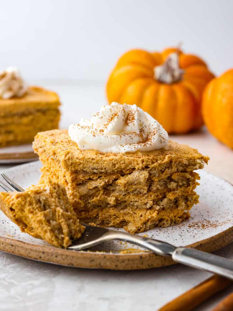 A slice of pumpkin icebox with a bite taken out with a fork.
