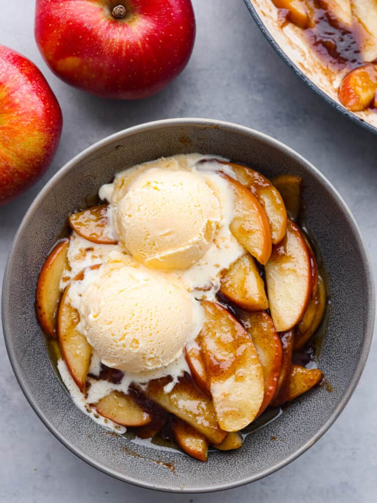 These apples are sautéed in an owl with vanilla ice cream on top. 