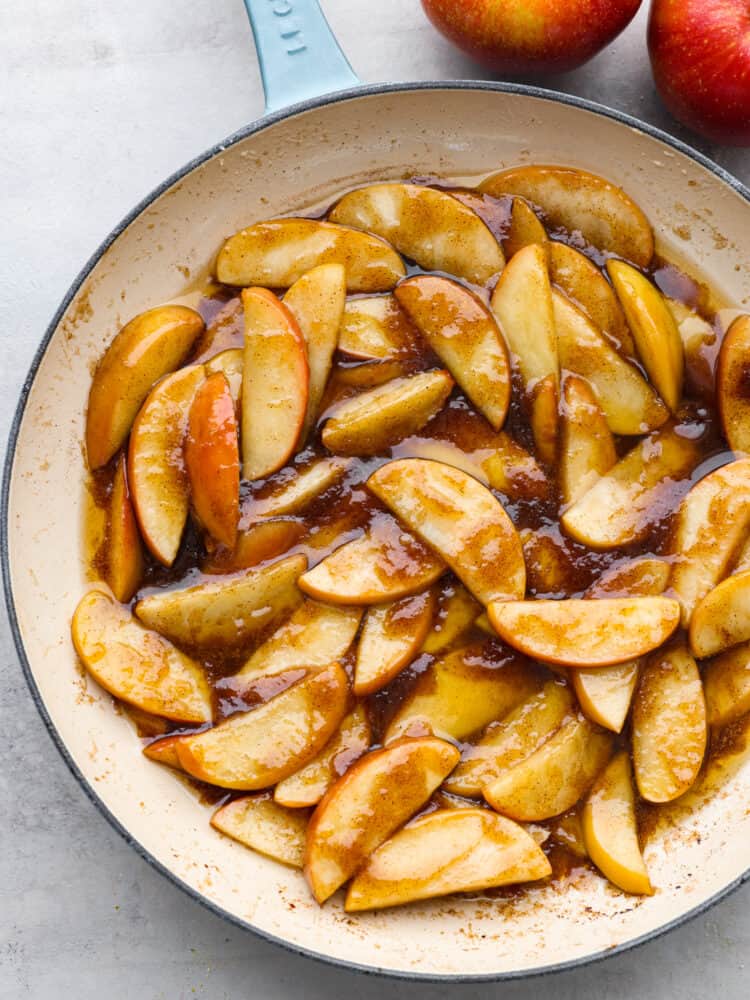 A pan filled with sauteed apples in a brown sugar, cinnamon sauce. 