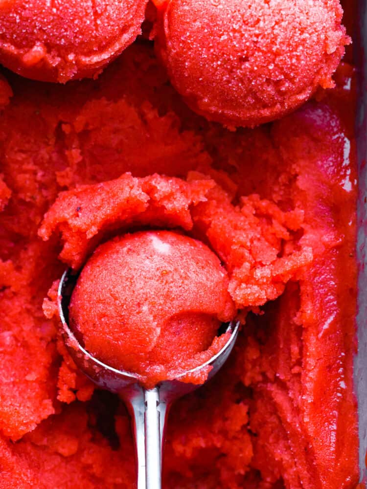 A closup of the strawberry sorbet in a scoop. 