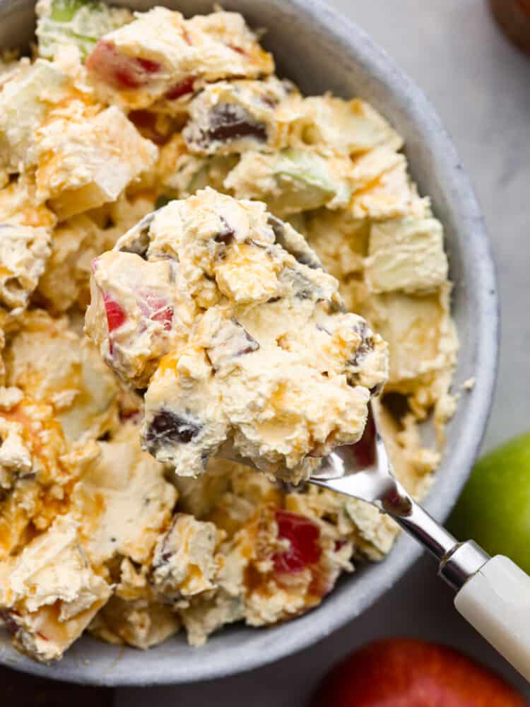 A closeup of snickers apple salad on a spoon. 