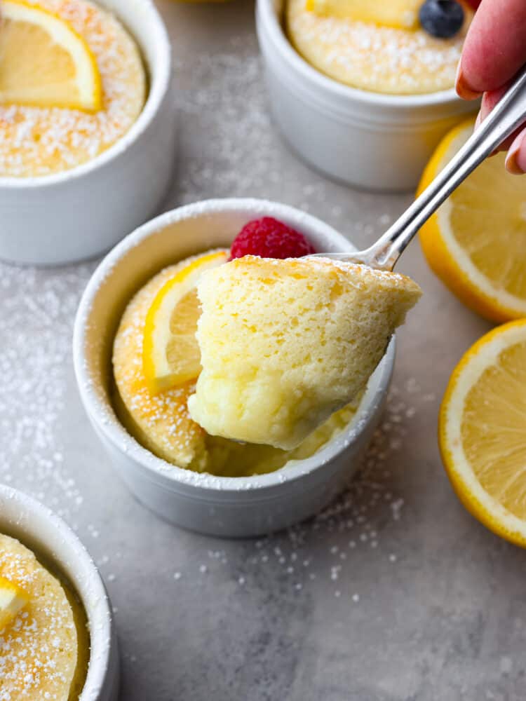 lemon pudding cake being scooped out with a spoon. 