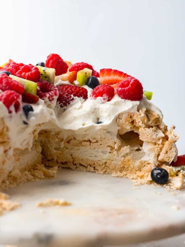 The side view of pavlova with a slice cut out. 