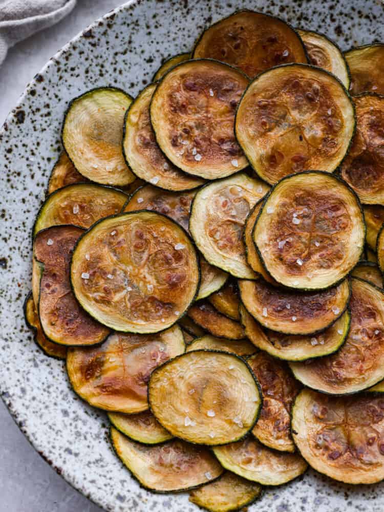 Baked zucchini chips on a platter. 