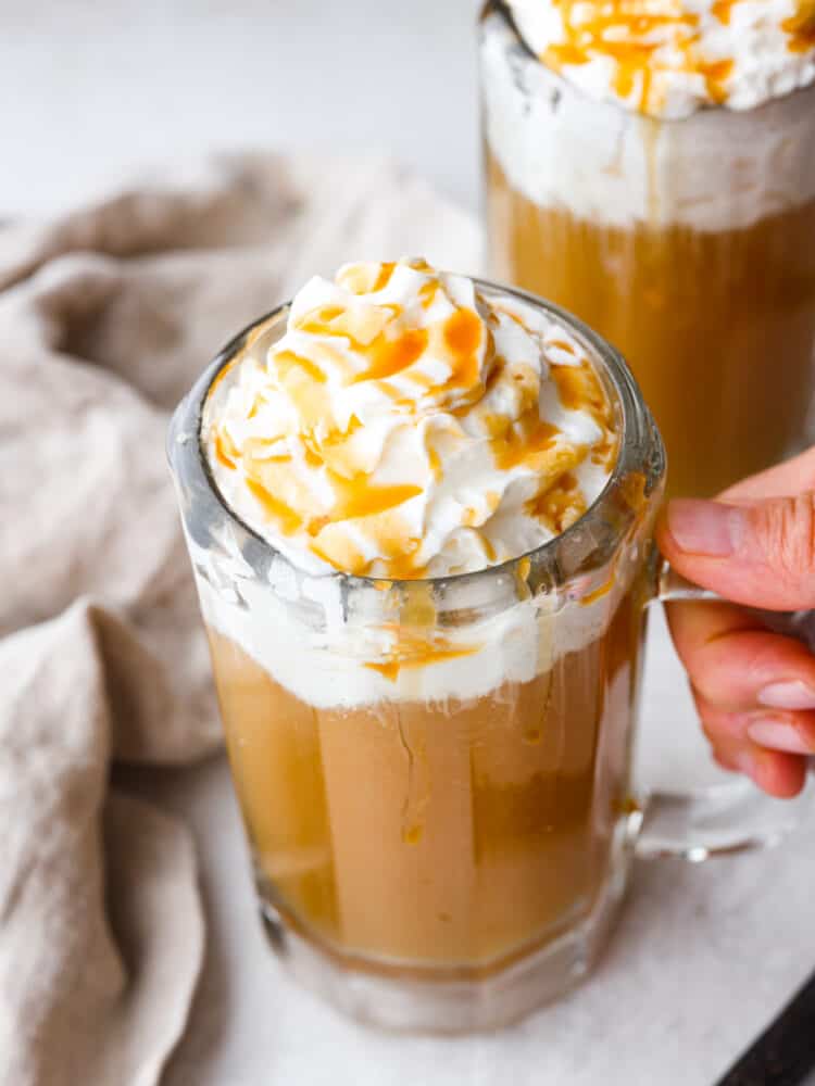 Closeup shot of butter beer in a glass mug being picked up.