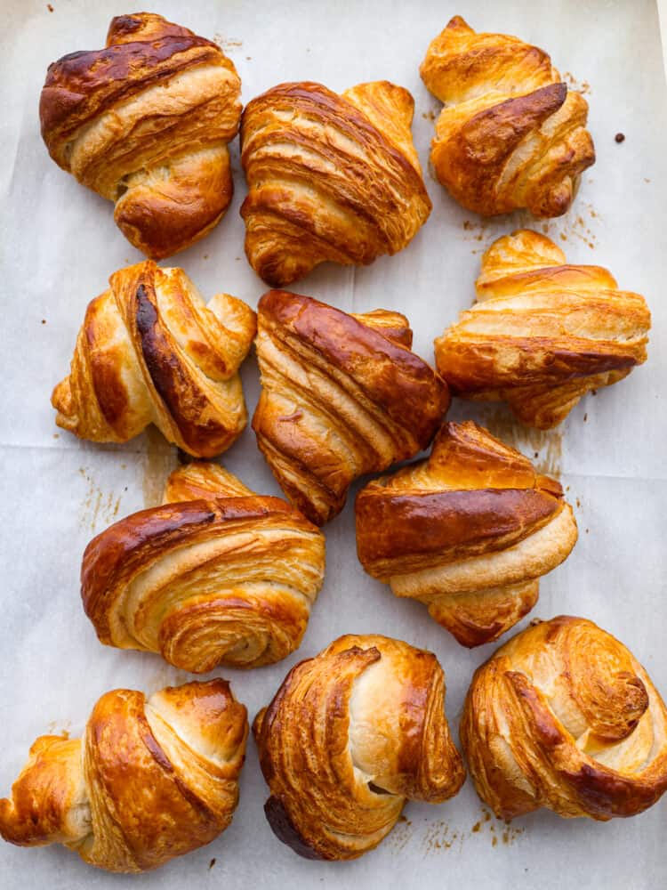 Top view of golden baked croissants on parchment paper.