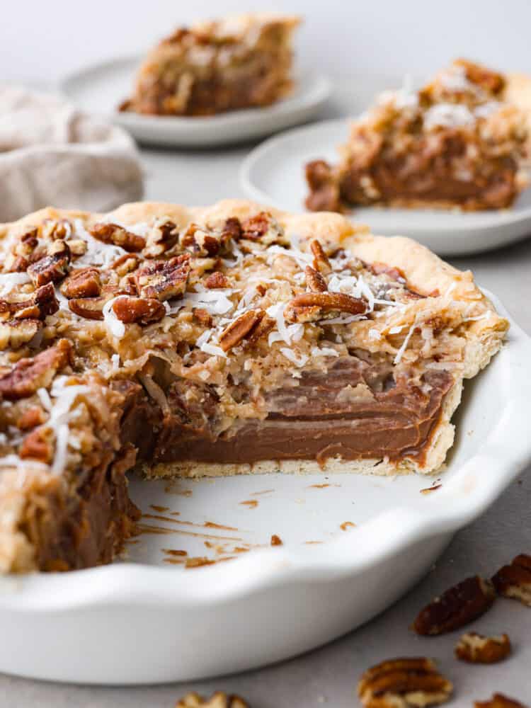 German chocolate pie in a pie dish with a slice cut out of it.