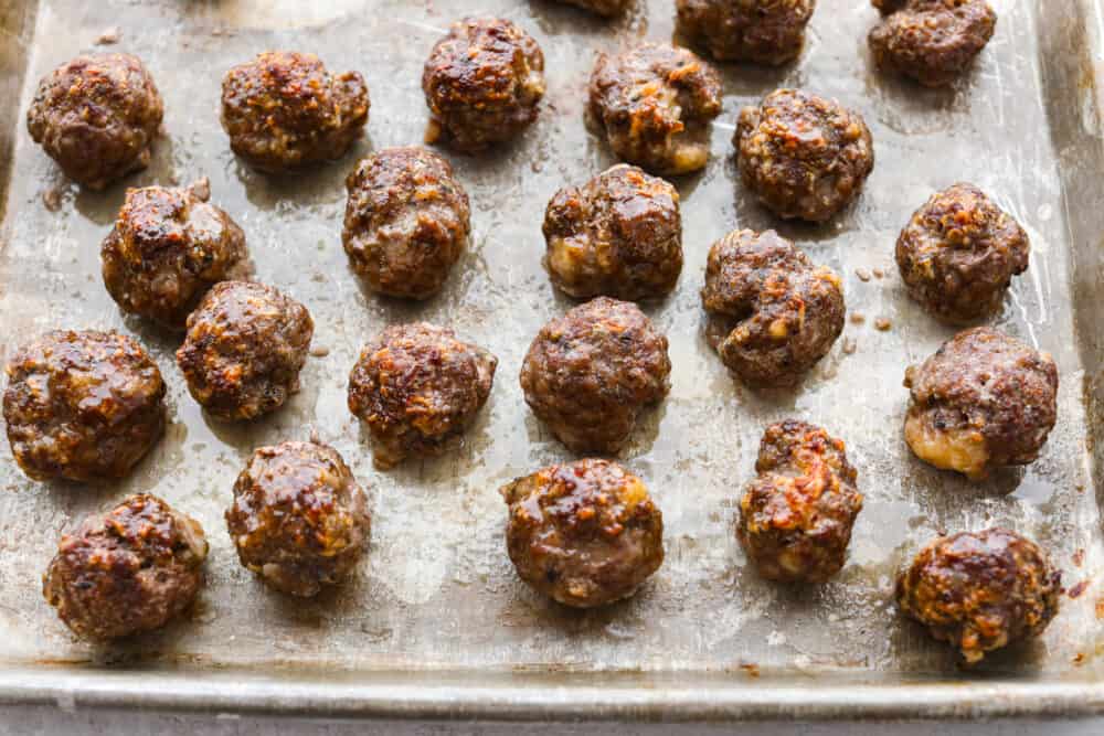 A pan filled with uncooked meatballs.
