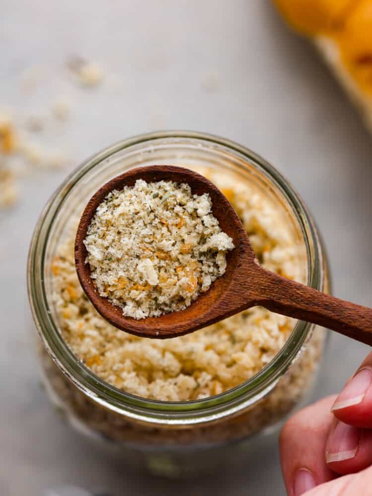 Closeup of homemade breadcrumbs in a wooden spoon.