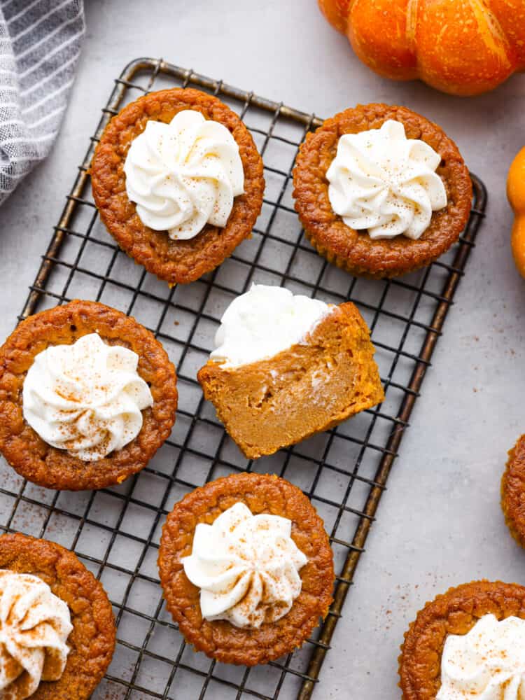 6 frosted pumpkin pie cupcakes on a cooling rack.