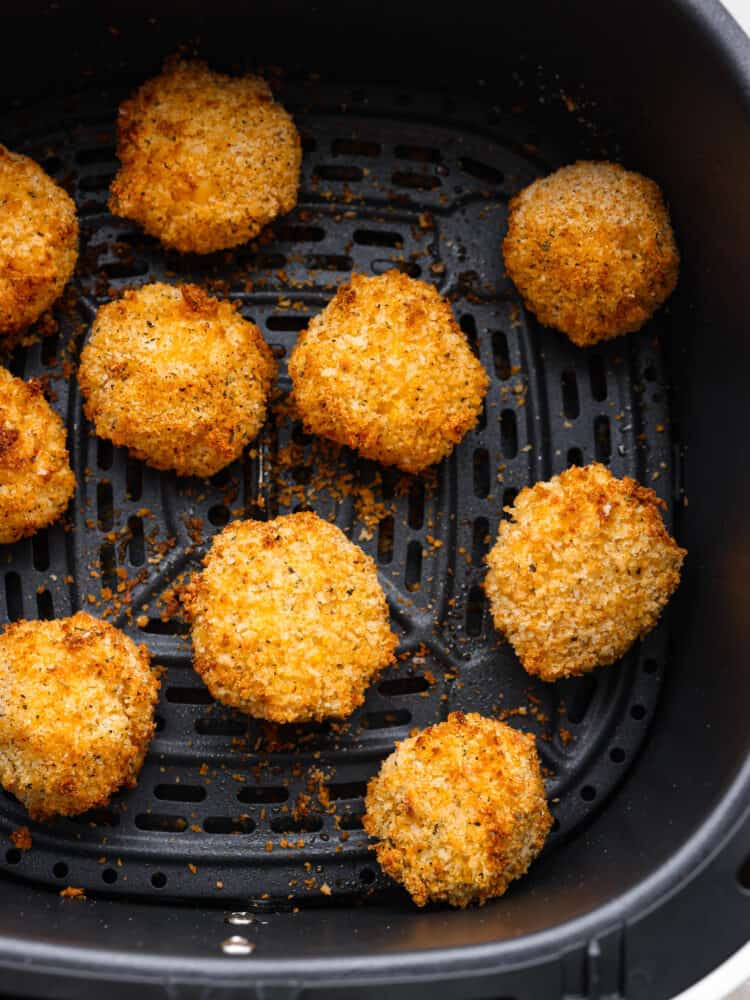 Cooked mac and cheese balls in an air fryer basket. 