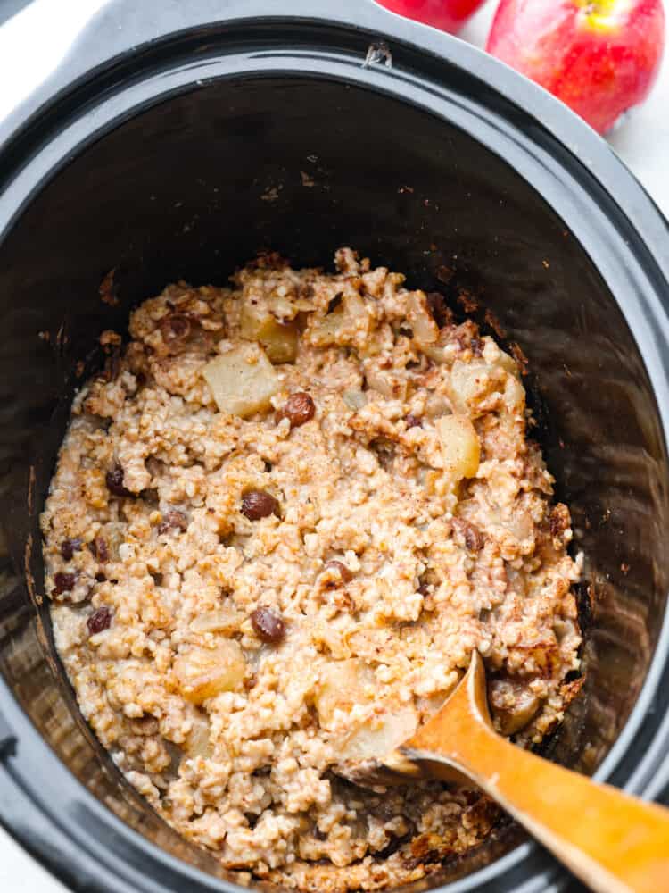 Cooked apple cinnamon oatmeal in a slow cooker.