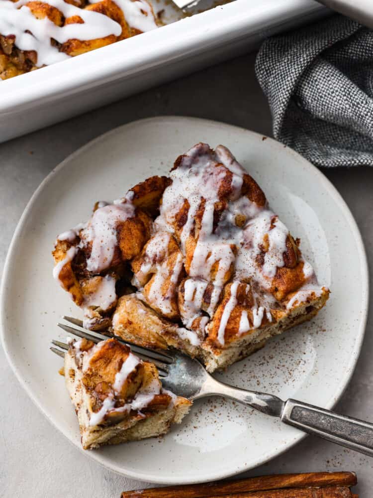 The top view of a slice of cinnamon French toast bake on a white plate with a fork. 