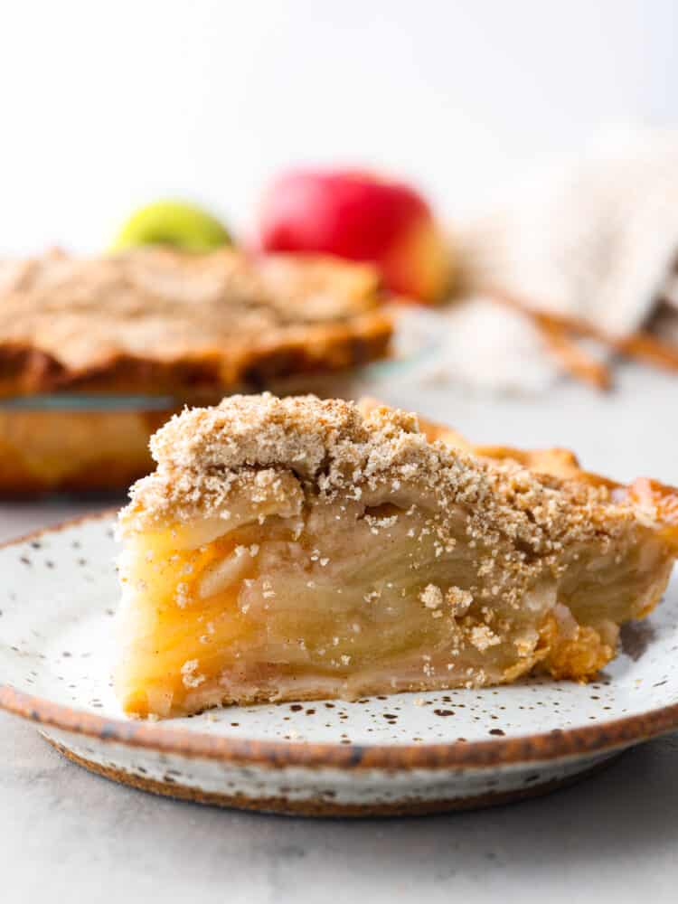 Closeup of a slice of apple pie on a stoneware plate.