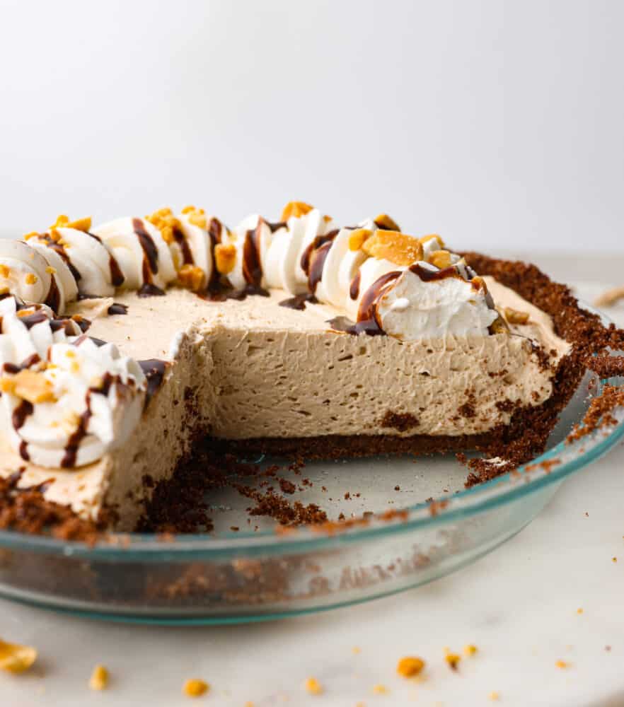 A peanut butter pie with a few slices cut out of it.